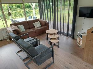 a living room with a couch and chairs and a table at De Dopheide | 4 persons in Gasselte
