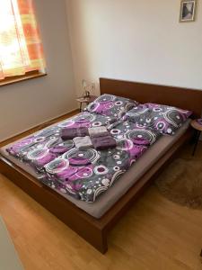 a bed in a bedroom with a purple blanket on it at Apartmán Diana in Oščadnica