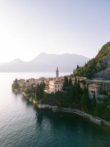 a town on a hill next to a body of water at Hotel Villa Cipressi, by R Collection Hotels in Varenna