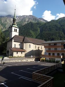 a church with a parking lot in front of it at Le Rustica, 3 rooms, 3 stars, 6 people in Les Houches