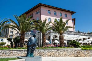 a statue of a man in front of a building at Luxury Nobile Apartment with private parking in Opatija