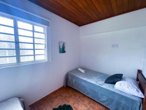 Giường trong phòng chung tại Chalés Fonte da Serra Monte Verde - MG