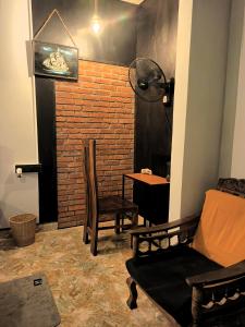a living room with a chair and a brick wall at Inside Weligama in Walliwala East