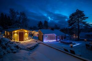 a house lit up in the snow at night at Norrby Tinyhouse in Pargas +6 photos