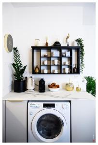 eine Waschmaschine in einer Küche mit einem Regal in der Unterkunft Entre Paris et le Chateau de Versailles - Parking in Rueil-Malmaison