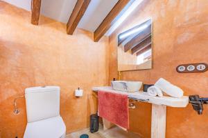 a bathroom with a toilet and a sink and a mirror at Natura 43 in Callosa de Ensarriá