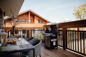 a grill on a deck with a table and chairs at Miracle Seasons in Liptovský Mikuláš +58 photos