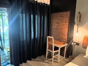 a table and chair in a room with a black curtain at Inside Weligama in Walliwala East