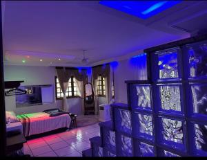a room with a bed and a room with blue lights at Aconchego by the lagoon in Araruama