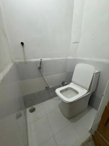 a small bathroom with a toilet in a stall at Double room with balcony in Prayagraj
