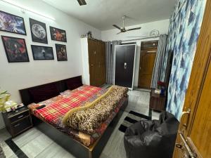 a bedroom with a bed with a blanket on it at Double room with balcony in Prayagraj +2 photos