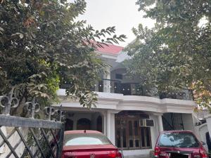 two cars parked in front of a house at Double room with balcony in Prayagraj