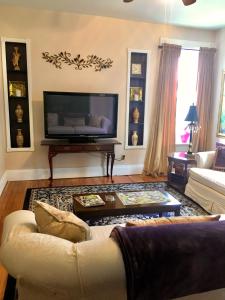 a living room with a couch and a tv at Historic Upstairs Apartment in Bellevue