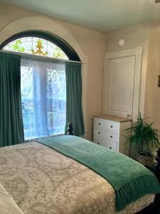 a bedroom with a bed and a large window at Historic Upstairs Apartment in Bellevue