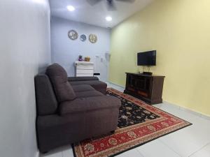a living room with a couch and a television at Ebnur Homestay in Arau