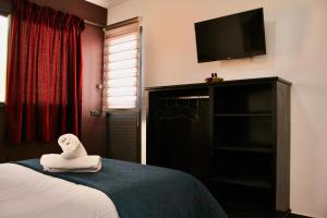 a hotel room with a bed and a flat screen tv at Peak House Imsouane in Imsouane