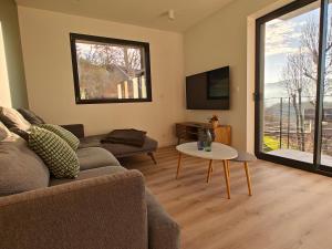 a living room with a couch and a table at La Fruitière de Vérel, logements modulables neufs, calmes, entre lac et montagne, max 11 personnes in Rovagny
