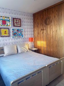 a bedroom with a large bed with a wooden wall at De bank van Nagele in Nagele