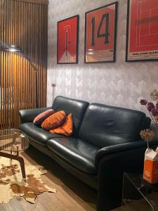 a black leather couch in a living room at De bank van Nagele in Nagele