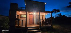 a small house with a front porch at night at Laslu in Punta Del Diablo
