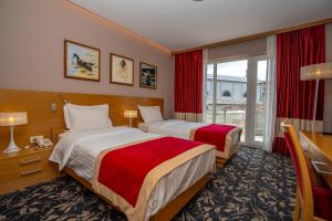 um quarto de hotel com duas camas e uma janela em Hotel Colosseo & Spa em Shkodër