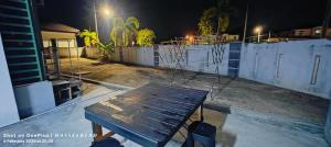 a wooden bench sitting in front of a fence at night at Vintage Houze, fully aircond, Wi-fi, Netflix, Coway in Alor Setar