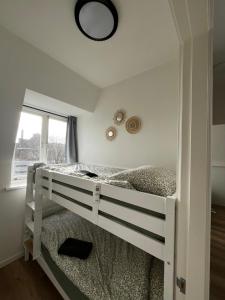 a white bunk bed in a room with a window at Apartement hotel Stays by ADM in Leiden