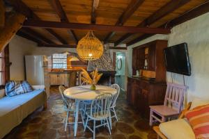 a kitchen and living room with a table and chairs at Cabañas La Oma Intiyaco in Atos Pampa