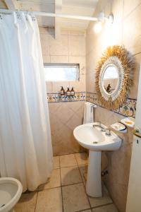 a bathroom with a sink and a toilet and a mirror at Cabañas La Oma Intiyaco in Atos Pampa +23 photos