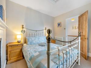a bedroom with a bed and a wooden night stand at Melrose Cottage in Cromer +12 photos