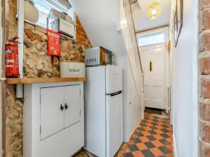 a kitchen with a white refrigerator and a tile floor at Melrose Cottage in Cromer