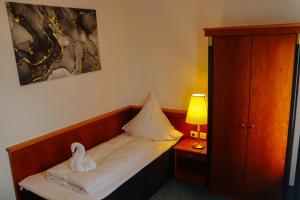 a room with a bed with a stuffed animal on it at Miros Restaurant Steakhaus Hotel in Langenfeld
