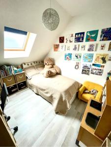 a bedroom with a teddy bear sitting on a bed at MAISON AVEC PISCINE BERGHEIM Village préféré des Français in Bergheim +15 photos