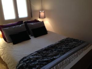 a bed with black and white sheets and pillows at Sta Maria Apartment in Tamariu