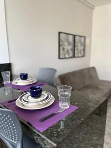 a table with plates and glasses on a purple napkin at LK Lourdes 12 in Belo Horizonte