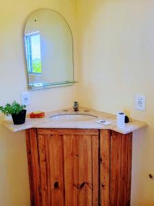 a bathroom with a wooden sink with a mirror at 28 de Octubre in Punta Del Diablo +11 photos