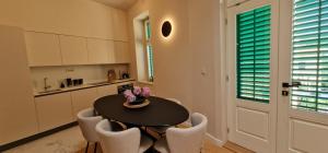 a kitchen with a black table and chairs and a table at Luxury Nobile Apartment with private parking in Opatija