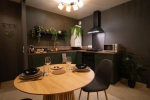 a kitchen with a wooden table and chairs in a kitchen at La Suite Nayara in Saint-Germain-sur-Morin
