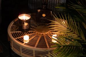 a table with candles and a bottle and a plant at La Suite Nayara in Saint-Germain-sur-Morin