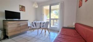 a living room with a couch and a table and a television at Les pieds dans l'eau ! in Cerbère