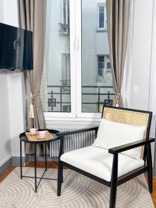 krzesło i stół w pokoju z oknem w obiekcie Cosy Hideaway Near Montparnasse w Paryżu