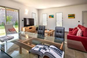 a living room with a glass table and a red couch at Villa with pool in Ramena, sea view in Ramena