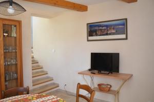 a living room with a television on a table and stairs at Maison conviviale avec piscine partagée à La Ciotat - 70 m² in La Ciotat