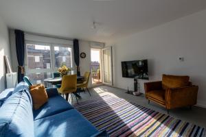 a living room with a blue couch and a table at Luxury à 10mn du Centre de Paris & Free Parking in Vitry-sur-Seine