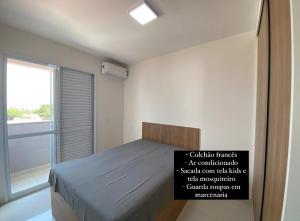 une chambre avec un lit avec un panneau dessus dans l'établissement Apto novo, com ar, acesso rápido ao centro, à Uberlândia