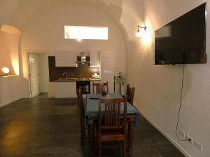 a kitchen and dining room with a table and a flat screen tv at Il Loft dell' americano in Narni