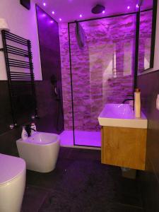a bathroom with a tub and a shower with purple lighting at Il Loft dell' americano in Narni