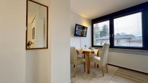 ein Esszimmer mit Tisch und Stühlen und einem Fenster in der Unterkunft Aparmtent im Münchner Westen, Parkplatz kostenfrei, ruhig in Gröbenzell