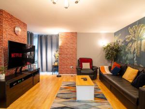 a living room with a couch and a tv at The Majestic Place - Sheffield City Centre in Sheffield