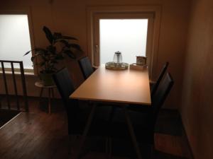 a dining room table with chairs and a window at Vrije Vlinders in IJzendijke